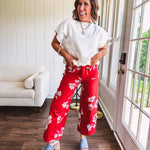 Wide leg cropped red pants with white florals throughout, button and zipper closure, wide cuffs and square front pockets. Minimal stretch