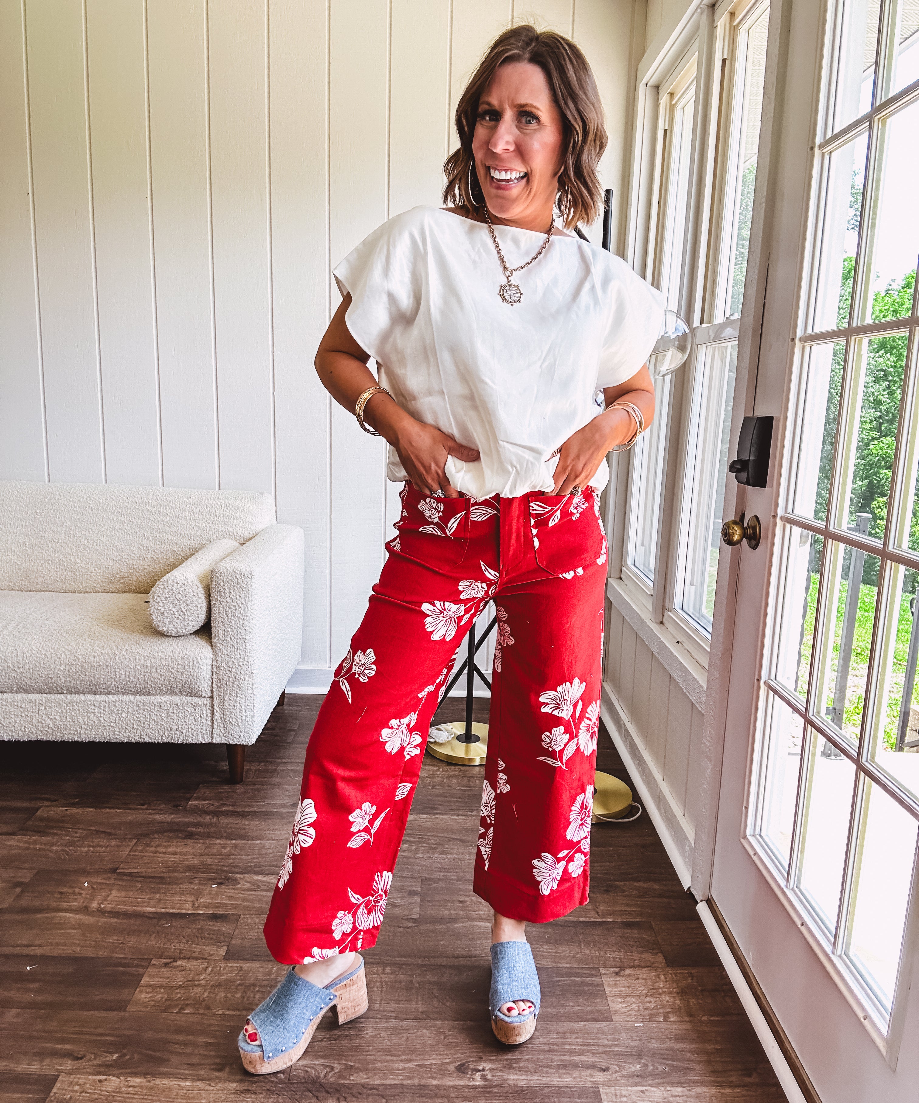 Wide leg cropped red pants with white florals throughout, button and zipper closure, wide cuffs and square front pockets. Minimal stretch
