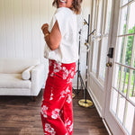 Wide leg cropped red pants with white florals throughout, button and zipper closure, wide cuffs and square front pockets. Minimal stretch