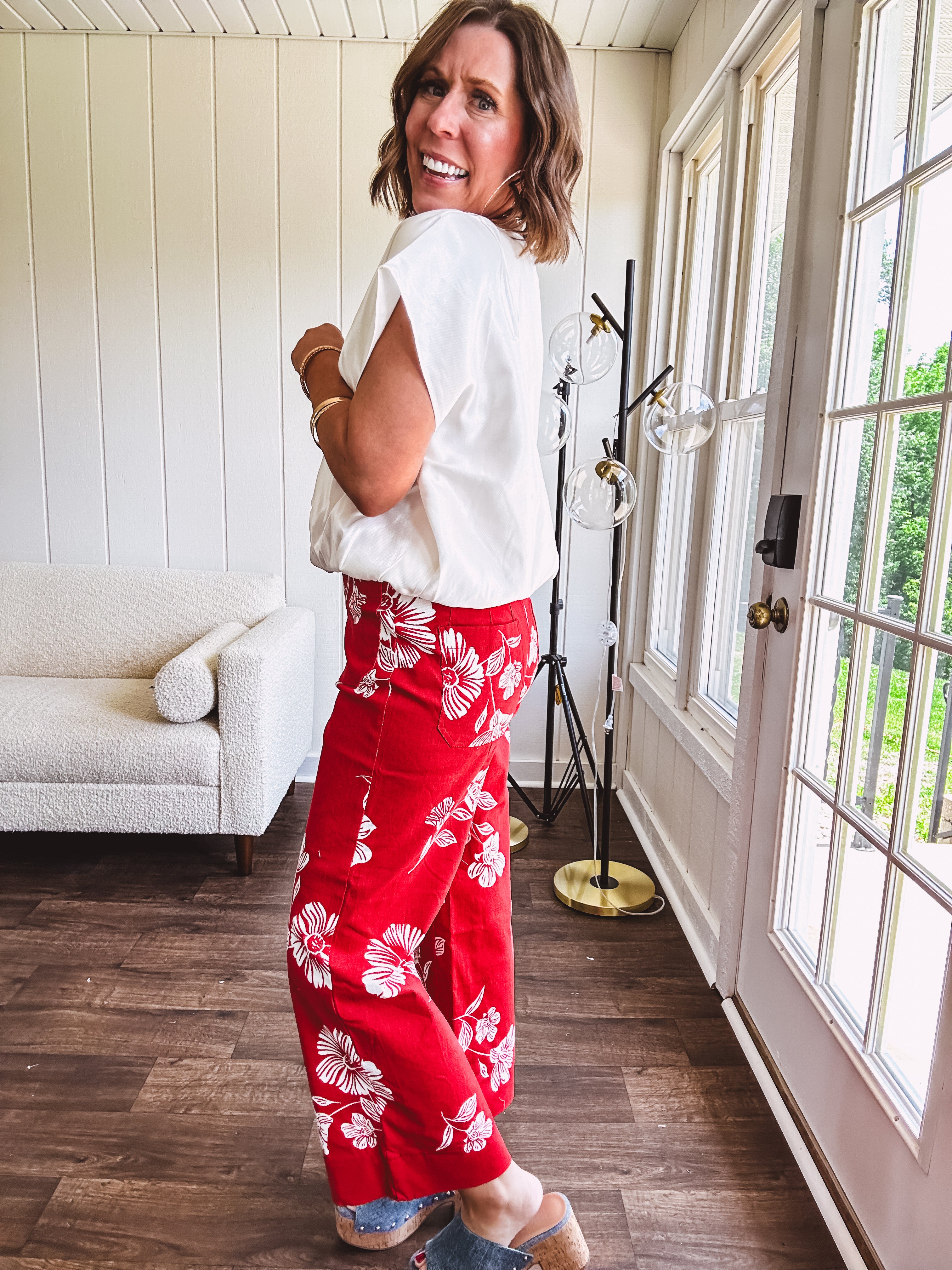 Wide leg cropped red pants with white florals throughout, button and zipper closure, wide cuffs and square front pockets. Minimal stretch