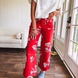 Wide leg cropped red pants with white florals throughout, button and zipper closure, wide cuffs and square front pockets. Minimal stretch