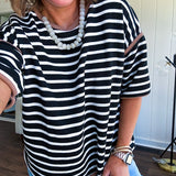 Soft, lightweight stretchy fabric in stripes including black and white, cream and white with contrasting trim at the round neck, hemline and sleeves. short sleeved and boxy cut.