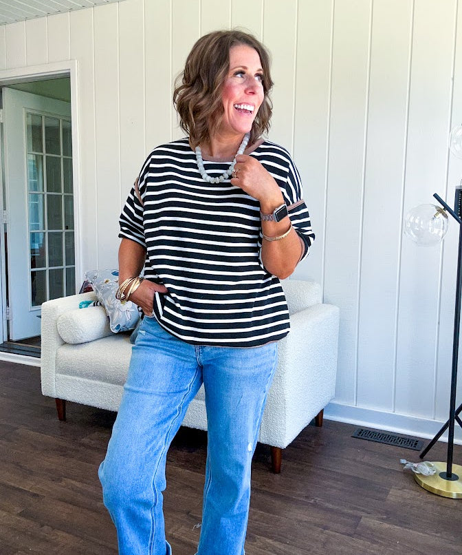 Light wash high rise denim with stretch, zipper button closure, minimal distressing and raw cutout at the hem with a straight leg design that is slim through the thighs.