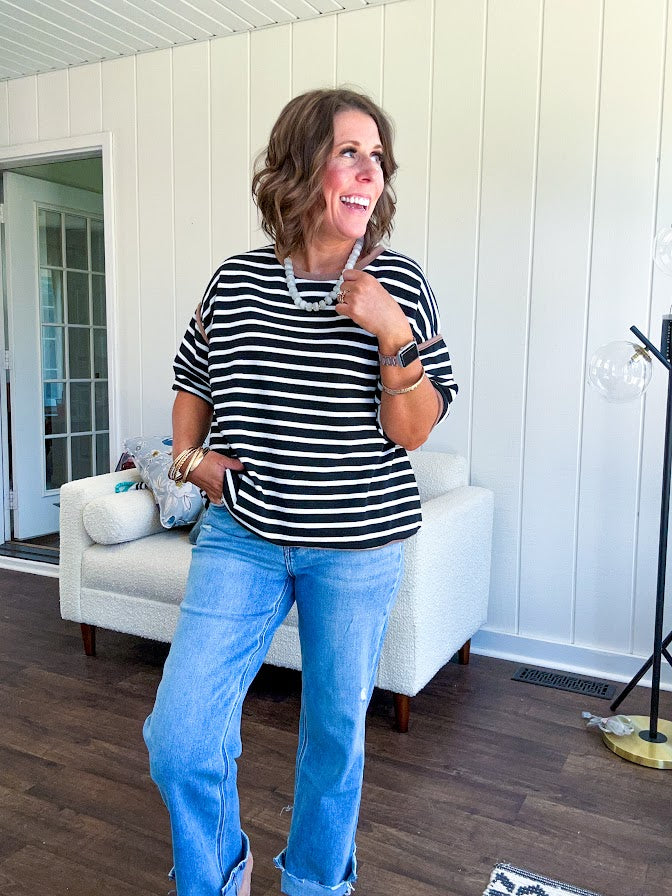 Light wash high rise denim with stretch, zipper button closure, minimal distressing and raw cutout at the hem with a straight leg design that is slim through the thighs.