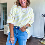 Soft, lightweight stretchy fabric in stripes including black and white, cream and white with contrasting trim at the round neck, hemline and sleeves. short sleeved and boxy cut.