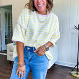 Soft, lightweight stretchy fabric in stripes including black and white, cream and white with contrasting trim at the round neck, hemline and sleeves. short sleeved and boxy cut.