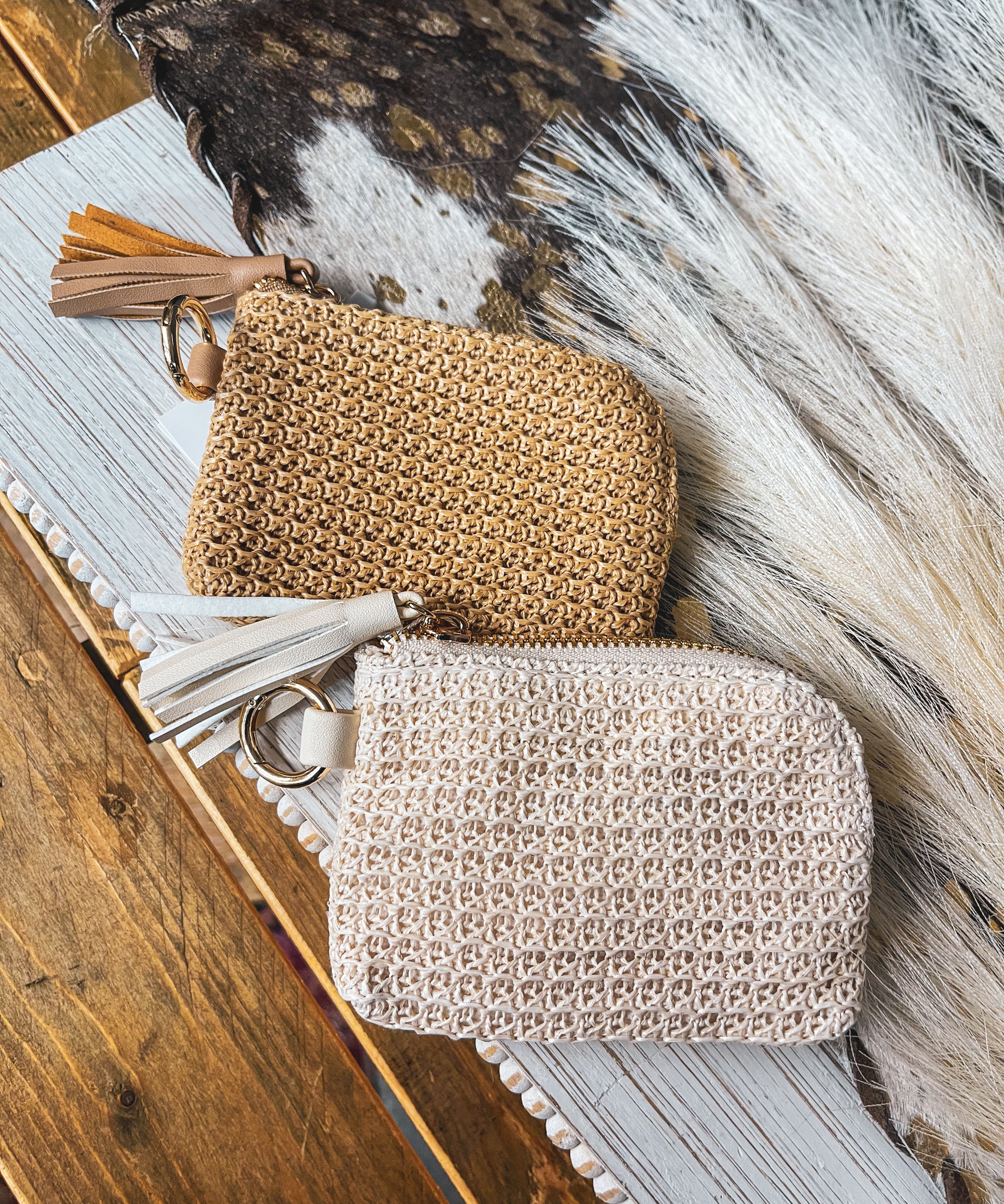 Small raffia card in or change holder in cream or tan with gold zipper, matching tassel and D ring for easy clipping to purse.