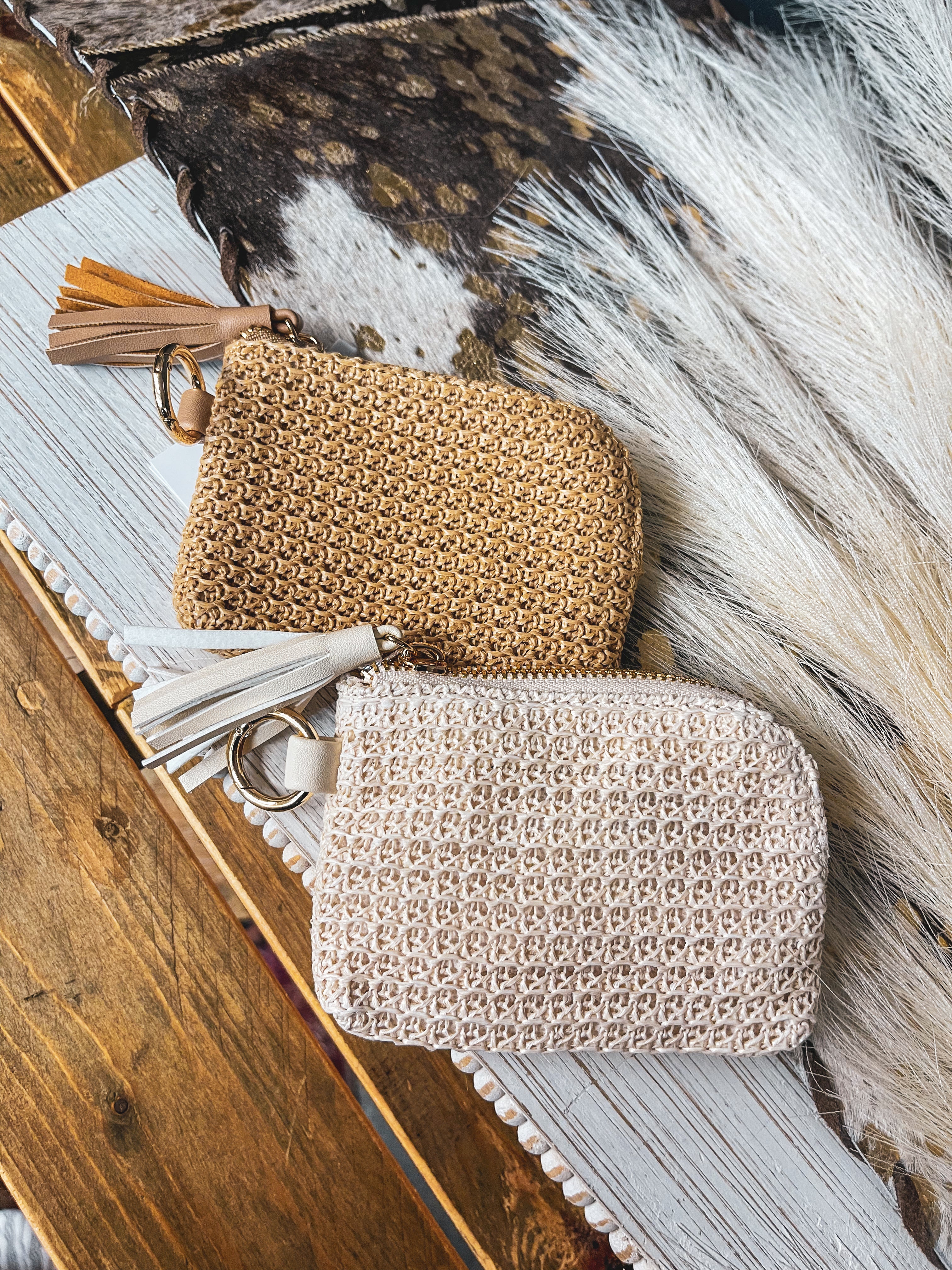 Small raffia card in or change holder in cream or tan with gold zipper, matching tassel and D ring for easy clipping to purse.