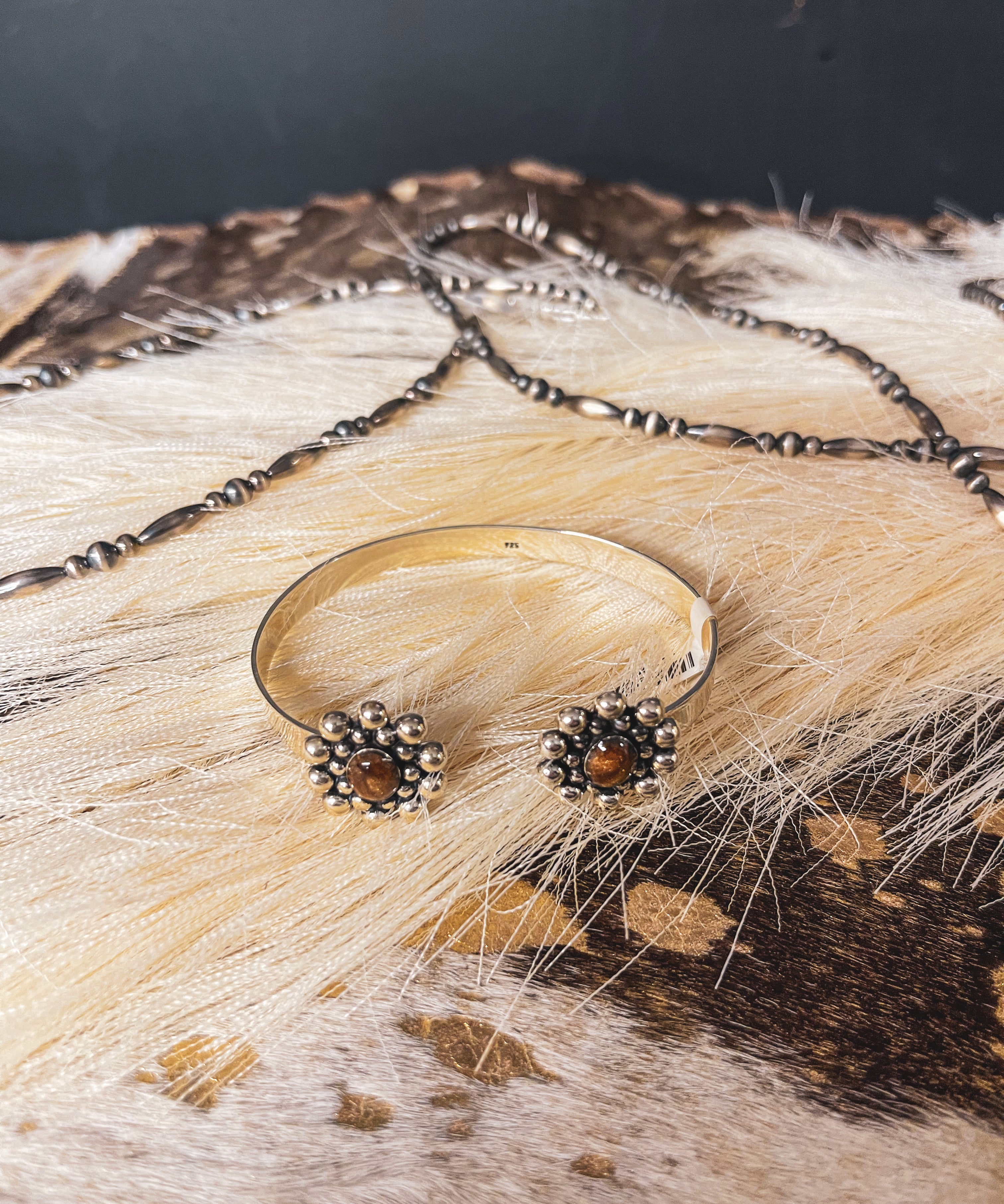 Authentic sterling silver balls surround a genuine Tiger's Eye oval on each end of this adjustable cuff with a sterling silver band.