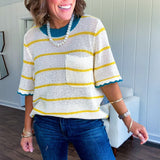 A boxy open weave cream knit that's equal parts playful and put-together. Sunshine-yellow stripes dance across the fabric while a bold teal collar and scalloped sleeve trim steal the show. The front pocket? Pure casual genius.