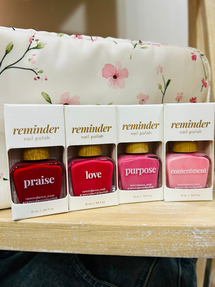 Nail polish in shades of red and pink with a QR code for worship verses.