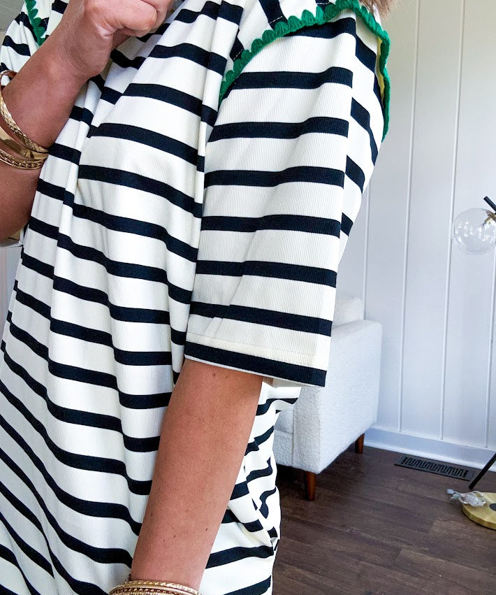 Black and cream striped short sleeved mini dress with green crochet trim at the shoulders. Has pockets.