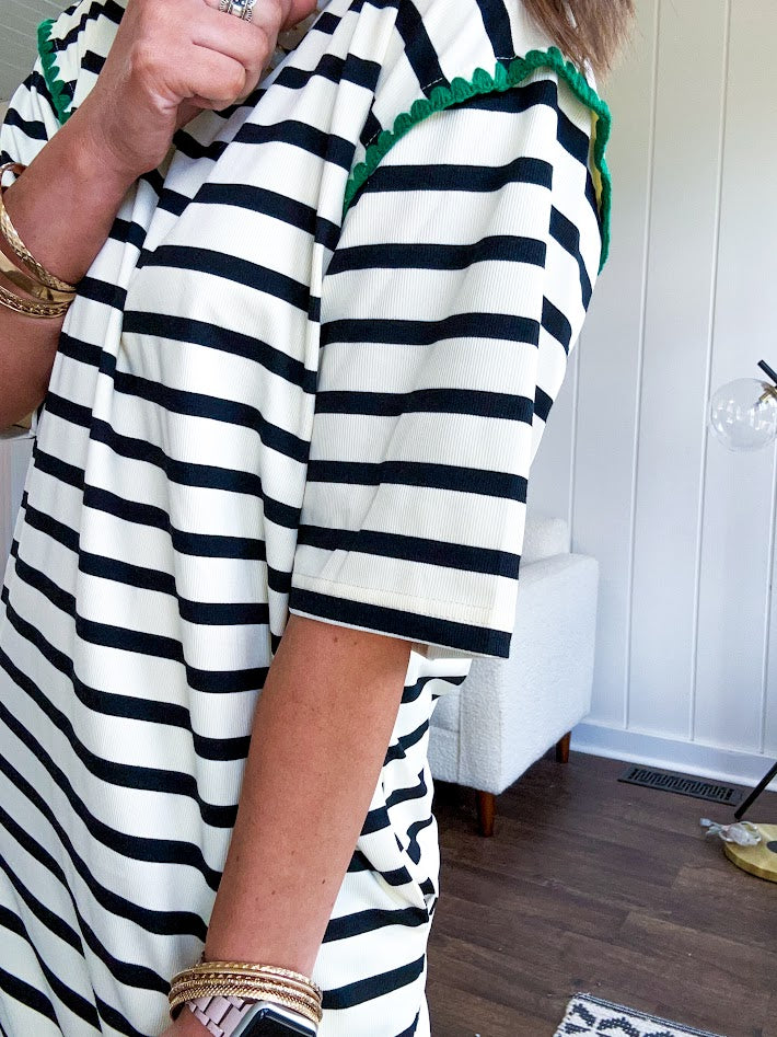Black and cream striped short sleeved mini dress with green crochet trim at the shoulders. Has pockets.