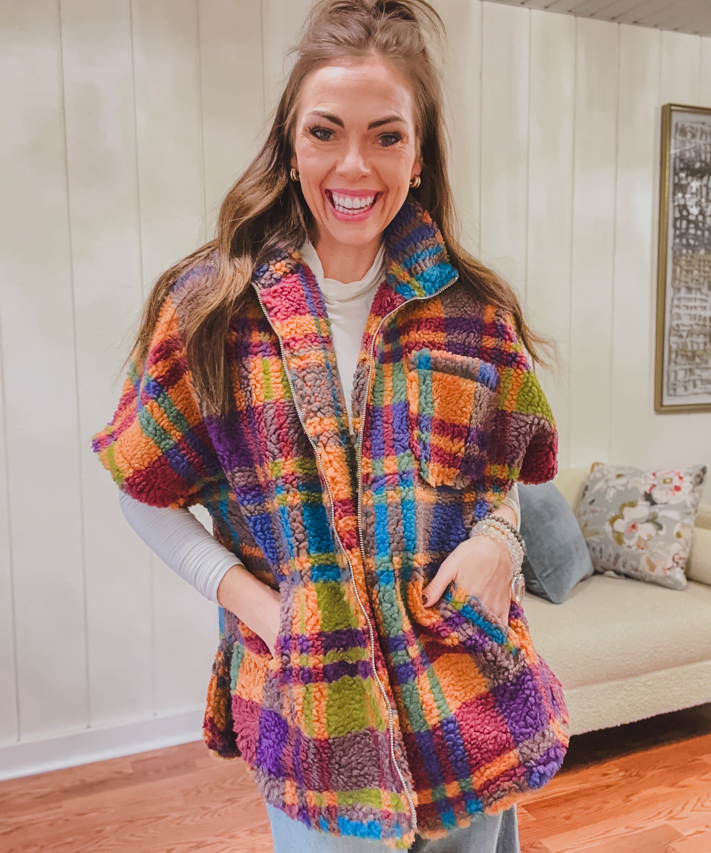 Short sleeved zip front sherpa jacket in bold orange, purple, pink and blue plaid with pockets.