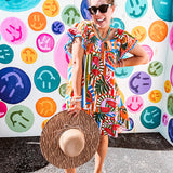 This tropical print short dress features vibrant summer hues with playful striping and fruit motifs throughout, square smocked neckline and flutter sleeves and pockets—complete with pink and blue ball tassels. Crafted from soft, lightweight fabric, it's designed to move with you all day long.