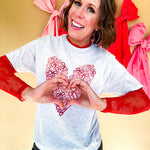 Light grey heathered tee with a pink and red heart made of bows on the front.