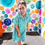 Teal and tan patterned mini dress with 1/4 button front and collar with short sleeves and pockets, fully lined.