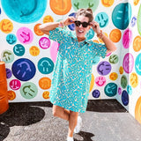 Teal and tan patterned mini dress with 1/4 button front and collar with short sleeves and pockets, fully lined.