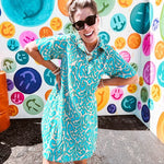 Teal and tan patterned mini dress with 1/4 button front and collar with short sleeves and pockets, fully lined.