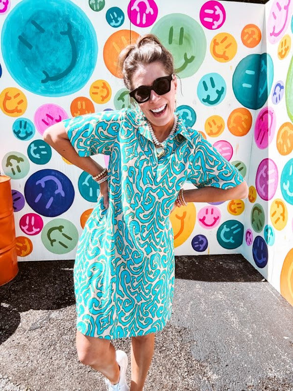 Teal and tan patterned mini dress with 1/4 button front and collar with short sleeves and pockets, fully lined.