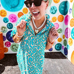 Teal and tan patterned mini dress with 1/4 button front and collar with short sleeves and pockets, fully lined.