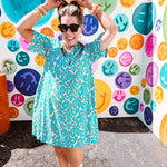 Teal and tan patterned mini dress with 1/4 button front and collar with short sleeves and pockets, fully lined.