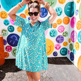 Teal and tan patterned mini dress with 1/4 button front and collar with short sleeves and pockets, fully lined.