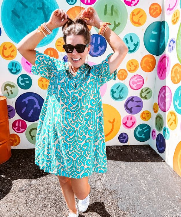 Teal and tan patterned mini dress with 1/4 button front and collar with short sleeves and pockets, fully lined.