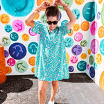 Teal and tan patterned mini dress with 1/4 button front and collar with short sleeves and pockets, fully lined.