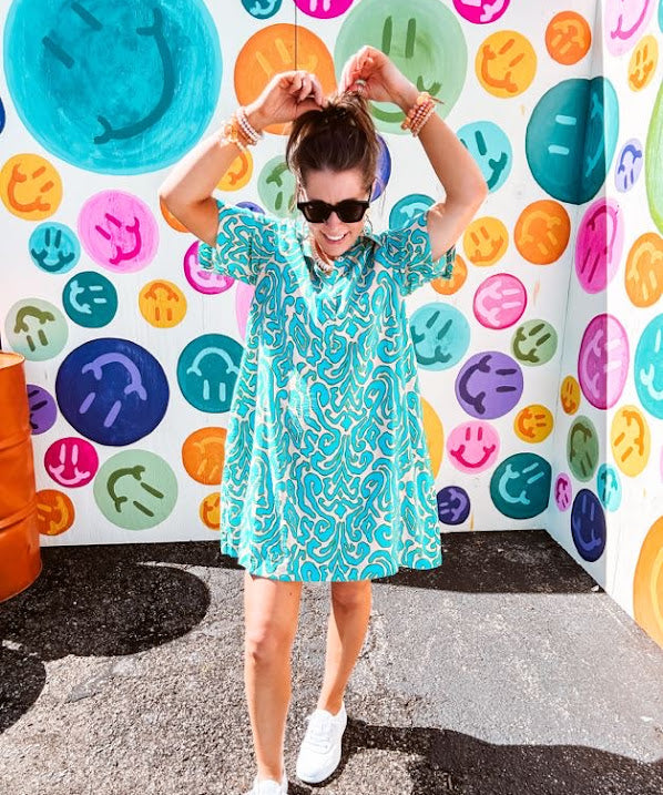 Teal and tan patterned mini dress with 1/4 button front and collar with short sleeves and pockets, fully lined.