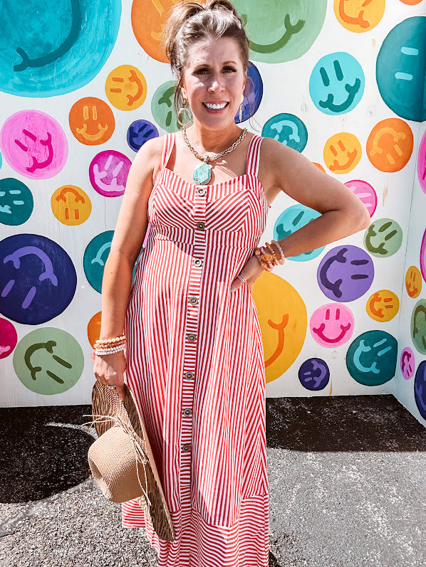 Red and white striped midi dress with sweetheart neckline and adjustable straps, wooden buttons and a wide strap, built-in elastic at the back and full lining.
