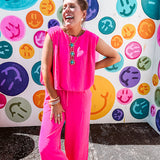 Fuchsia set including a bubble hem, sleeveless blouse with pleated shoulders and wide-leg pants with pockets.