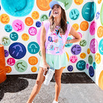 Cool pink cotton sleeveless tee with a shorter hemline with "Be Salty Stay Lit" multi colored retro inspired graphic on the front.