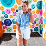White shorts with lining and textured outer layer with elastic drawstring waist with wooden ends on the ties.