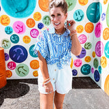 White shorts with lining and textured outer layer with elastic drawstring waist with wooden ends on the ties.