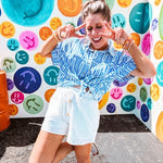 White shorts with lining and textured outer layer with elastic drawstring waist with wooden ends on the ties.