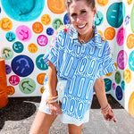 Light blue and white geometric short sleeved button down with collar and cuffed sleeves with bold orange, green and pink embroidery on the shoulders.