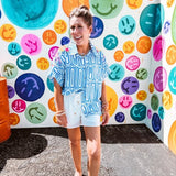White shorts with lining and textured outer layer with elastic drawstring waist with wooden ends on the ties and pockets.
