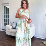Fully lined flowy halter dress in seafoam green with green and coral tropical print, V neck with button option, matching silky belt and pockets. Midi length.