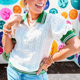 Nearly sheer ivory eyelet patterned blouse with a collar, puff sleeves and three large rhinestone floral buttons at the neckline. The collar, cuffs and hem are a contrasting bright green with pink athletic striping.