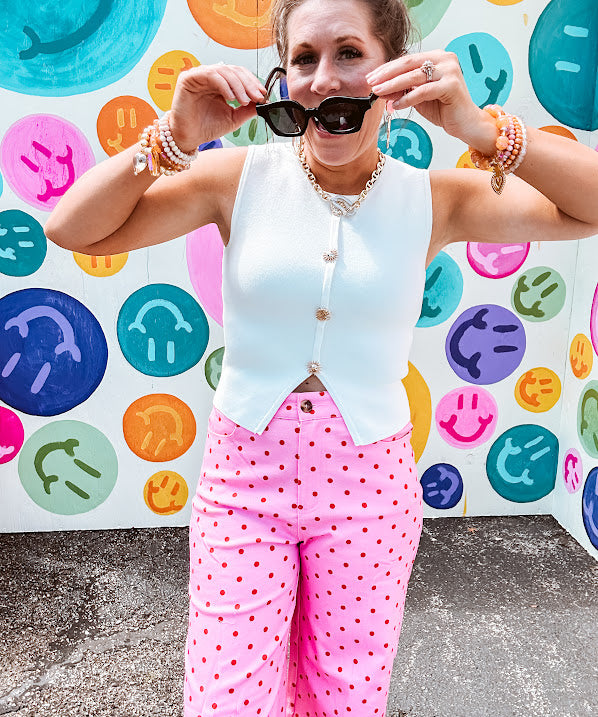 Soft, chic white button vest with gold shell and sun faux buttons down the front and a peekaboo front hem, round neck.