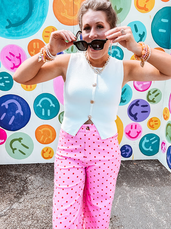 Soft, chic white button vest with gold shell and sun faux buttons down the front and a peekaboo front hem, round neck.