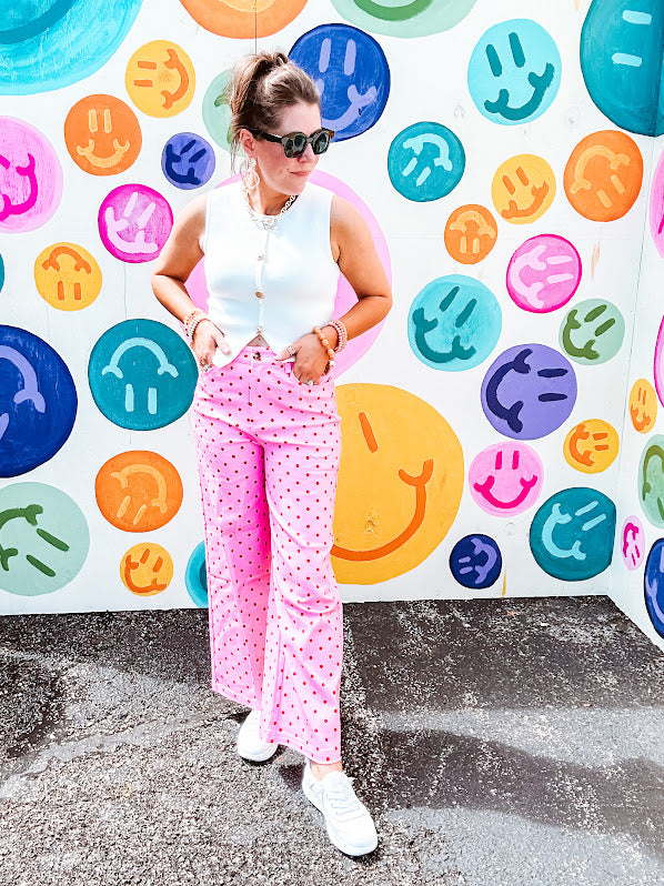 Warm pink lightweight button and zipper closure wide leg pants with red polka dots throughout with side and back pockets.