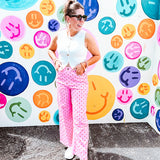 Warm pink lightweight button and zipper closure wide leg pants with red polka dots throughout with side and back pockets.