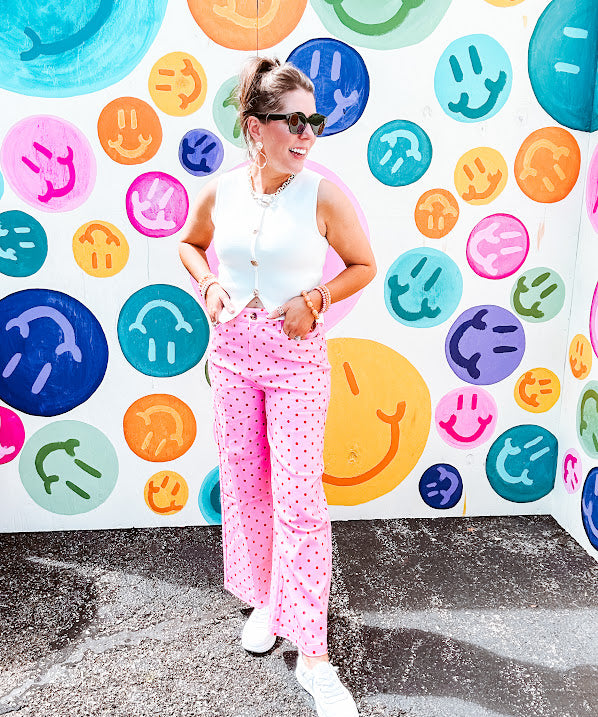 Warm pink lightweight button and zipper closure wide leg pants with red polka dots throughout with side and back pockets.
