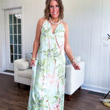 Fully lined flowy halter dress in seafoam green with green and coral tropical print, V neck with button option, matching silky belt and pockets. Midi length.