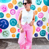 Warm pink lightweight button and zipper closure wide leg pants with red polka dots throughout with side and back pockets.