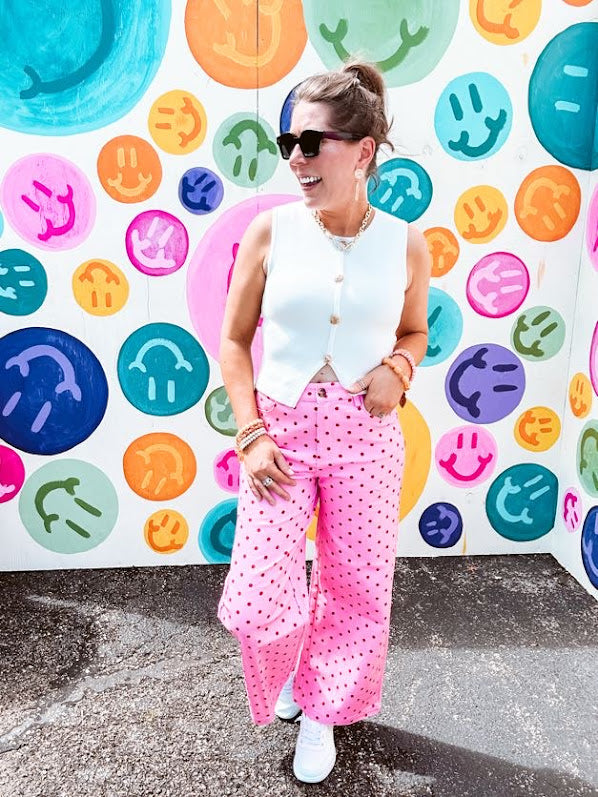 Warm pink lightweight button and zipper closure wide leg pants with red polka dots throughout with side and back pockets.