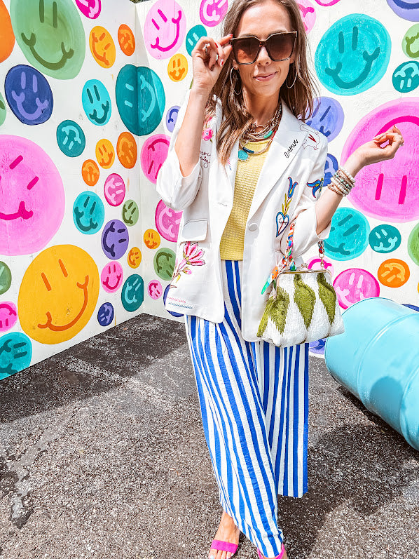 Cream fitted blazer with vibrant floral embroidery and French embroidered —"j'taime," "amour," "bisou, bisou"—with structured shoulder padding and scrunched sleeves.
