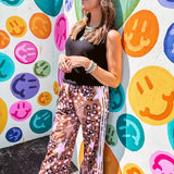 Satiny wide leg pants with drawstring waist in light brown with leopard print, light pink stars and tan stars with athletic ivory striping down the sides and side pockets.